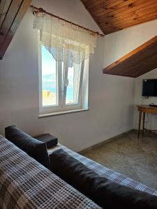 a bedroom with a window with a view of the beach at Apartmani Banić Apartman 4 in Postira +14 photos