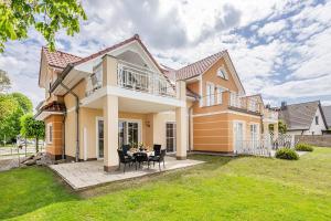 a house with a table and chairs in the yard at Ferienwohnung Auszeit am Meer in Koserow
