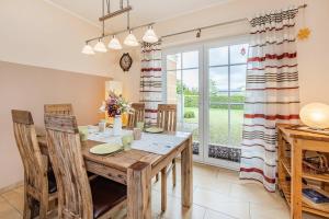 a dining room with a wooden table and chairs at Ferienwohnung Auszeit am Meer in Koserow