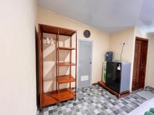a room with a shelf and a television in it at Amaro Homestay in Nuhu Tawun