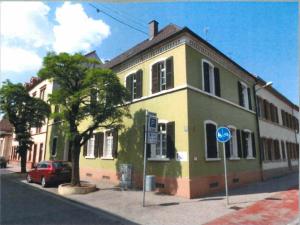 a yellow and green building on the side of a street at Villa Doll Germersheim in Germersheim