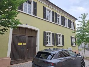 a car parked in front of a yellow house at Villa Doll Germersheim in Germersheim
