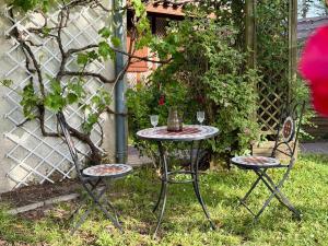 a table and two chairs with wine glasses on it at Maisonnette près du lac in Léon