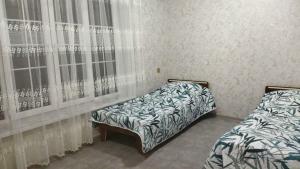 a bedroom with two beds and a window at TamoLand in Astara