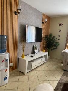 a living room with a tv and a white cabinet at Shikaz Homes 2 Bedroom Near Jkia Airport in Nairobi