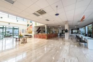 an empty lobby with tables and chairs in a building at THB Royal in Playa Blanca