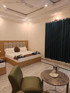 a bedroom with a bed and a table and chairs at Blue Breeze in Haridwār