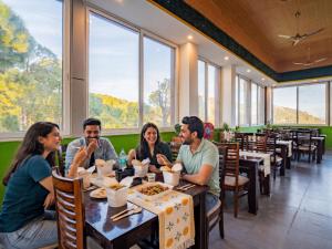 a group of people sitting at a table in a restaurant at The Hosteller Lansdowne in Lansdowne