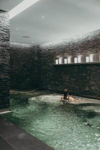 a woman is in a pool of water at Hotel Schweizerhof Bern & Spa in Bern