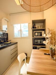a kitchen with a wooden table and a microwave at Comodo dpto para 2 en pleno centro de Salta - Bonavista Rentals in Salta +8 photos