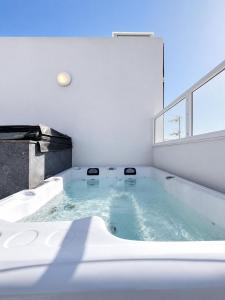 a large bath tub in a room with a window at Prestigious & Modern SeaView Penthouse with Private Jacuzzi in Marsaskala