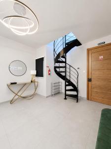 a spiral staircase in a living room with a television at Prestigious & Modern SeaView Penthouse with Private Jacuzzi in Marsaskala