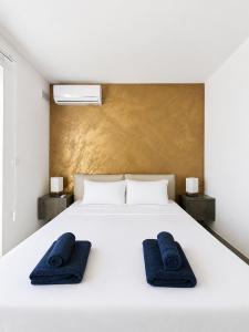 a white bed with two blue towels on it at Prestigious & Modern SeaView Penthouse with Private Jacuzzi in Marsaskala +21 photos