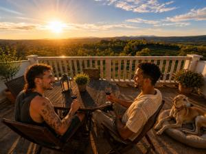two men sitting at a table with glasses of wine at El Triskel de Chumbea- Confort y naturaleza en la Sierra de Béjar in Navalmoral de Béjar