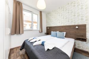 a bedroom with a large white bed with blue pillows at Nova City Apartments in Budapest