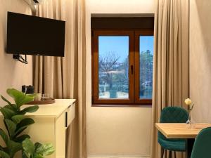 a hotel room with a window and a table with a chair at Central Lux in Petrovac na Mlavi