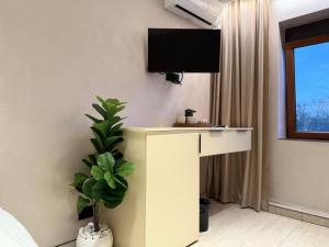 a room with a desk with a tv on the wall at Central Lux in Petrovac na Mlavi