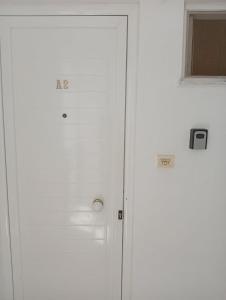 a white door with a window in a room at Gikas Apartments Triple Studio Garden View A2 in Marmari