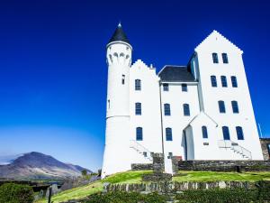 a white church on a hill with mountains in the background at Iveragh Heights in Cahersiveen