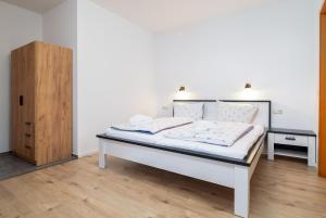 a bedroom with a bed and a wooden cabinet at Meeresbrise in Thiessow