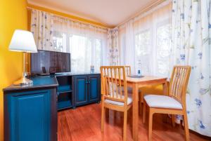 a dining room with a table and chairs and a kitchen at Dünenrose in Thiessow