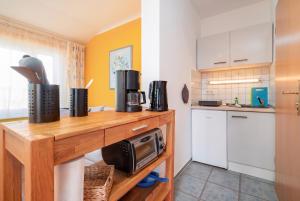 a kitchen with a wooden counter with a microwave at Dünenrose in Thiessow