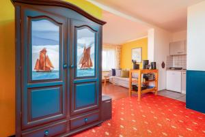 a living room with a blue cabinet with glass doors at Dünenrose in Thiessow +7 photos