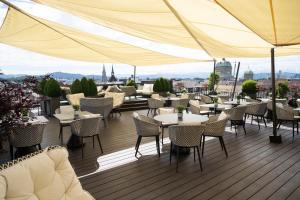 a restaurant with tables and chairs on a deck at Hotel Schweizerhof Bern & Spa in Bern