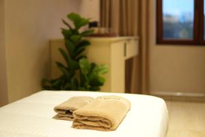 two towels sitting on top of a bed at Central Lux in Petrovac na Mlavi