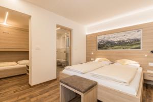 een slaapkamer met een groot bed en een spiegel bij Appartamenti Vilin in San Cassiano