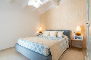 a bedroom with a blue bed with two lamps on it at Borgo Myricae in Chia +74 photos