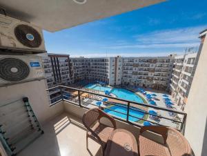 a balcony with a view of a swimming pool on a apartment at Tiba Golden beach resort hurghada down town in Hurghada