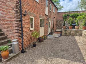 a brick building with potted plants in front of it at Chestnuts Barn in Belper