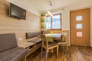 een eetkamer met een tafel, stoelen en een bank bij Appartamenti Vilin in San Cassiano