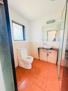 a bathroom with a toilet and a sink at Baga Central Studio Apartment in Baga +45 photos
