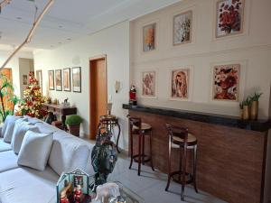 a living room with a couch and a bar at confortável suite no jardim Botânico in Ribeirão Preto