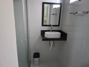 a bathroom with a sink and a mirror at confortável suite no jardim Botânico in Ribeirão Preto