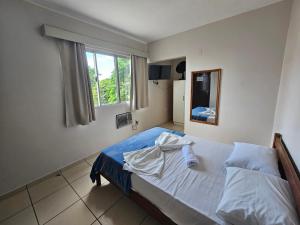 a bedroom with a bed and a window at Ok Inn Hotel Express in Tubarão