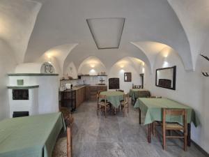 a room with tables and chairs and a kitchen at Foresteria Traversi in Berbenno di Valtellina