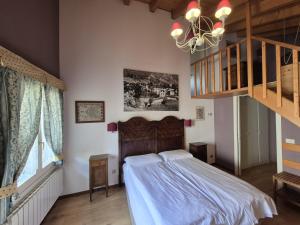 a bedroom with a large bed and a staircase at Foresteria Traversi in Berbenno di Valtellina