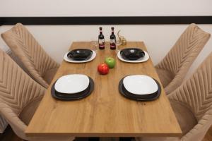 a wooden table with bottles of wine and an apple on it at Numero Uno LUX in Sombor