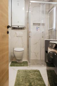 a bathroom with a toilet and a shower with a sink at Numero Uno LUX in Sombor