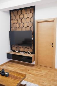 a living room with a television and a door at Numero Uno LUX in Sombor
