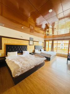 a large bedroom with a large bed and a couch at Hinjuma guest house in Leh