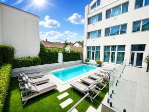 a swimming pool with lounge chairs and a building at ARIS Boutique Hotel & SPA in Oradea