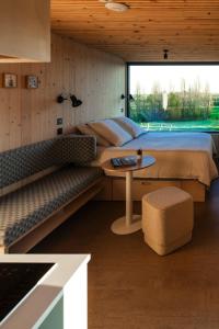a bedroom with a bed and a table and a couch at Vineyard Cabins at Château Puynard in Berson