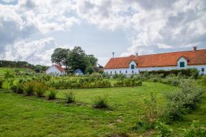 a white building with a red roof in a field at Nøddehaven in Eg