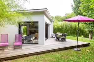 a wooden deck with a table and chairs and an umbrella at Villa Les Lodges Terre et Mer in Concarneau
