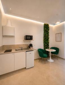 a kitchen with a table and chairs and a green wall at Sanctuaire bien-être in Sélestat