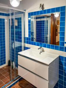 a bathroom with a white sink and blue tiles at Villa GioCar in Castelsardo